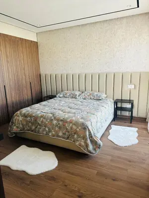 a bedroom with a bed with pillows and two rugs at Studio Adam 18 CFC 2 minutes away in Casablanca