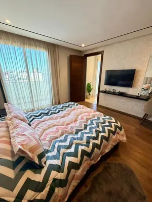 a bedroom with a large bed and a flat screen tv at Studio Al Mahdi 23 CFC 2 minutes away in Casablanca