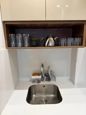 a kitchen counter with a sink and glasses on a shelf at Studio Al Mahdi 23 CFC 2 minutes away in Casablanca