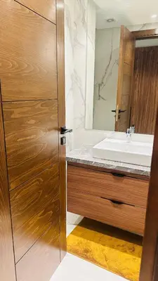 a bathroom with a wooden door and a sink at Studio Iza 08 CFC à 2mn in Casablanca