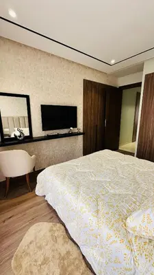 a bedroom with a large bed and a television at Studio Iza 08 CFC à 2mn in Casablanca