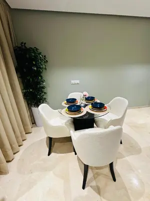 a table with white chairs and plates on it at Studio le César 6 CFC 2 minutes away in Casablanca