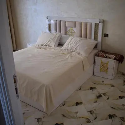 a bed with white sheets and pillows in a bedroom at tanger in Aïn Diab