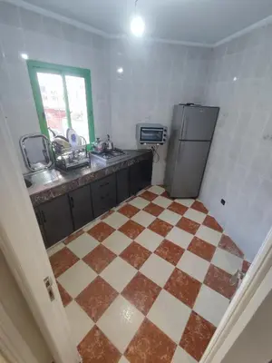 a kitchen with a refrigerator and a tiled floor at tanger in Aïn Diab