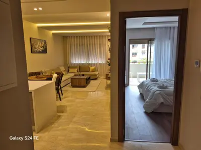 a living room with a couch and a bed in a room at aeroperla 15 aéroport casa blanca in Nouaseur