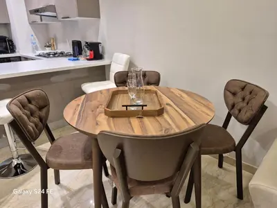 a wooden table with chairs around it in a kitchen at aeroperla 15 aéroport casa blanca in Nouaseur