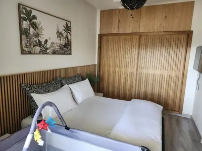 a bedroom with a bed with a wooden wall at Rita in Mohammedia