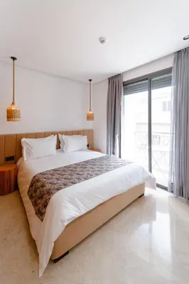 a bedroom with a large bed and a large window at Spinoza House Suite de luxe Casablanca - Maarif in Casablanca