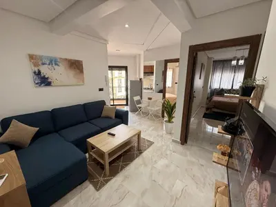 a living room with a blue couch and a table at Urban Loft - by Nero in Casablanca