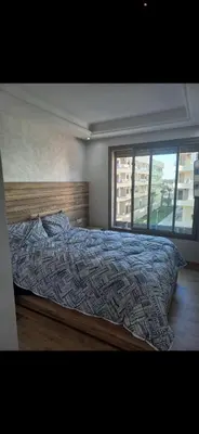 a bedroom with a bed and a large window at Residence Garden Paradise plage luxe in Bouznika