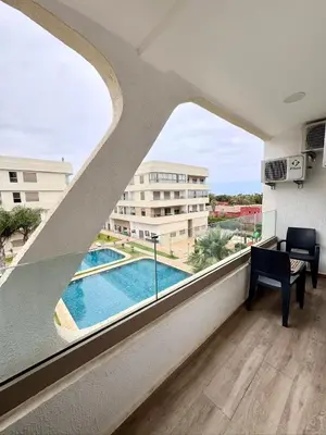 a view from the balcony of a building with a pool at Residence Garden Paradise plage luxe in Bouznika
