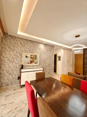 a living room with a wooden table and red chairs at L'Écume Des Sablettes in Mohammedia