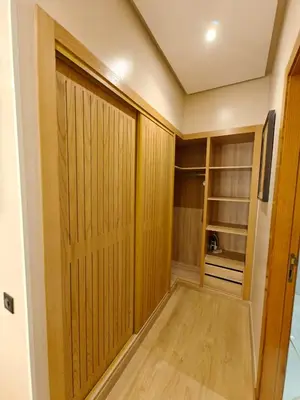 a walk in closet with wooden panels and a door at Appart Moderne Vue mer latérale & piscine - Plage des Sablettes El Mansouria in O Ben Slimane