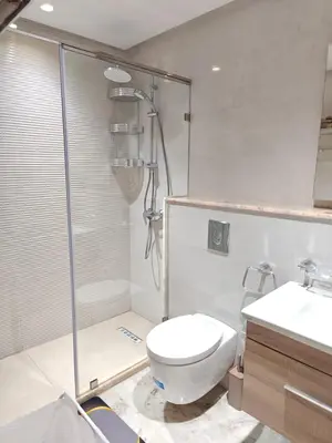 a bathroom with a shower and a toilet and a sink at Appart Moderne Vue mer latérale & piscine - Plage des Sablettes El Mansouria in O Ben Slimane