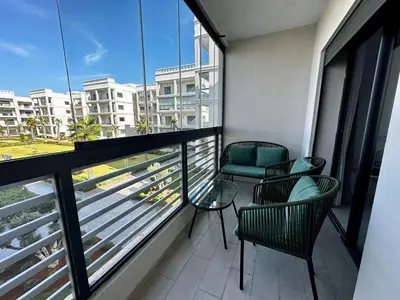 a balcony with chairs and a view of a city at APT Luxueux à Costa Beach 3 avec Piscine et accès Plage in Bouznika