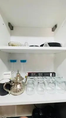 a shelf with glasses and a tea kettle on it at CAN STADIUM VIEW Luxurious Place Prestigia Hay Riad in Rabat