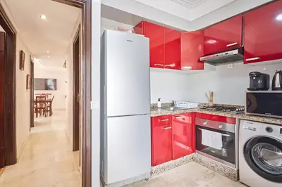 a kitchen with red cabinets and a white refrigerator at 2BR Getaway Near and Seaside Promenade in Casablanca