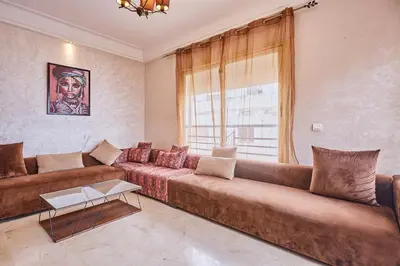 a living room with a brown couch and a window at 2BR Getaway Near and Seaside Promenade in Casablanca