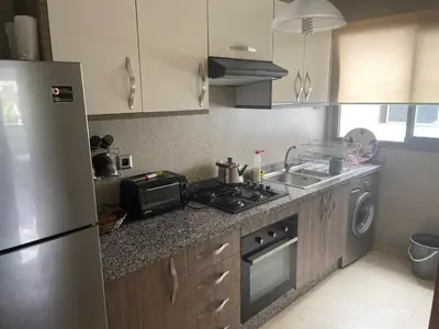 a kitchen with a stove and a sink and a refrigerator at La perle de blanca beach in Sidi Rahal