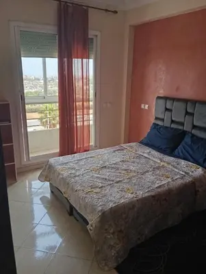 a large bed in a room with a large window at Sara Appartement in Casablanca