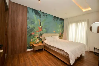 a bedroom with a large bed with a tropical wallpaper at Antonio Cerezo in Maarif