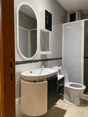 a bathroom with a sink and a toilet and a mirror at coastal charm harhoura in Temara