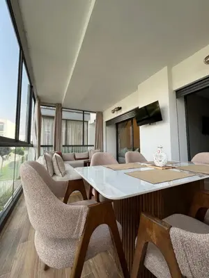a room with chairs and a table and a tv at Appartement cosy et confortable in Casablanca