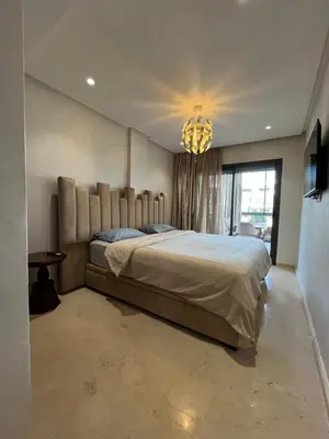 a bedroom with a large bed and a chandelier at Appartement cosy et confortable in Casablanca