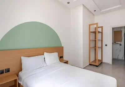 a bedroom with a white bed with an arch above it at Appartement de luxe 2 chambres PS5,AC,Fibre,Netflix à agdal Au coeur de Rabat in Rabat