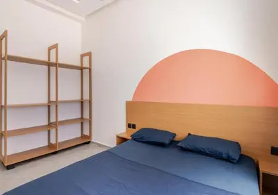 a bedroom with a bed and shelves in it at Appartement de luxe 2 chambres PS5,AC,Fibre,Netflix à agdal Au coeur de Rabat in Rabat