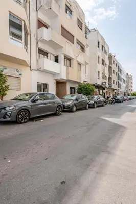 a row of cars parked on the side of a street at Appartement de luxe 2 chambres PS5,AC,Fibre,Netflix à agdal Au coeur de Rabat in Rabat