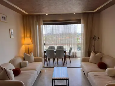 a living room with a couch and a table and chairs at Grand appartement la corniche vue panoramique sur Casablanca in Casablanca