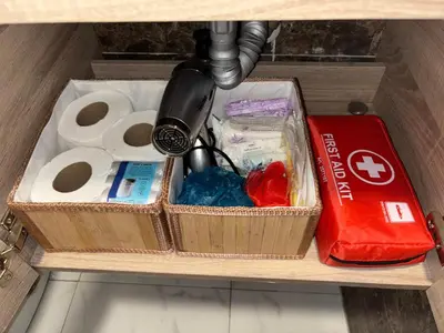 a drawer with toilet paper and other items on a shelf at Chez A&J, appartement climatisé, proche du Stade de Rabat in Temara