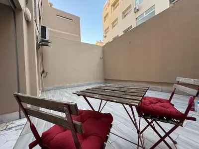 a wooden table and two chairs on a balcony at Modern studio with large terrace and parking in Casablanca
