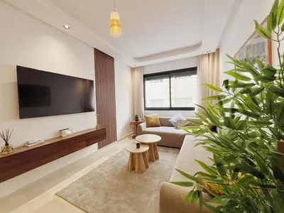 a living room with a couch and a flat screen tv at Cosy Central Appart in Casablanca Best Location in Maarif