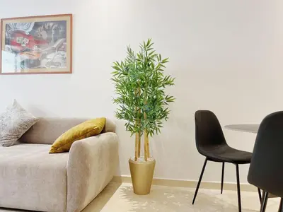 a living room with a couch and a potted plant at Cosy Central Appart in Casablanca Best Location in Maarif
