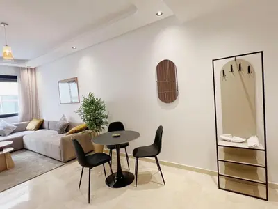a living room with a couch and a table and chairs at Cosy Central Appart in Casablanca Best Location in Maarif