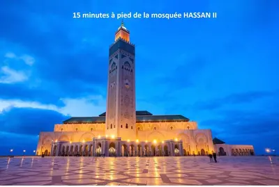 a large building with a clock tower at night at Appartement à Gauthier, Casablanca in Casablanca