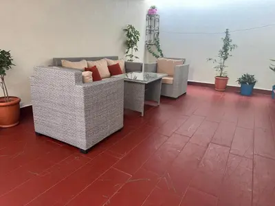 a room with two couches and a table and plants at Hideaway Rosa Parc Mohammedia in Mohammedia