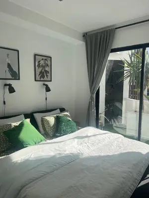 a bedroom with a bed with green pillows and a window at Stay IN GAUTHIER studio M in Casablanca