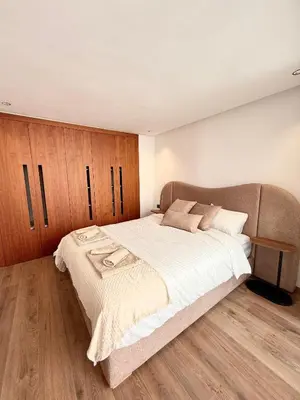 a bedroom with a large bed and wooden cabinets at Adresse remarquable casablanca in Casablanca