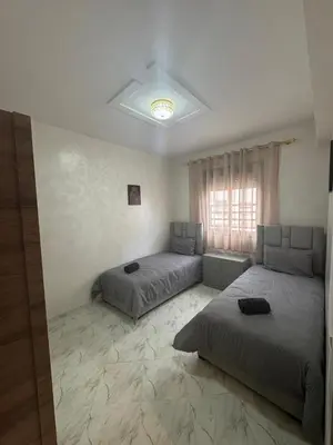 a bedroom with two beds and a window at Appartement Casablanca près de la mer in Dar Bouazza