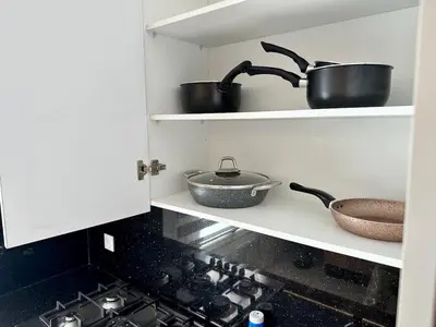 a kitchen with some pots and pans on a shelf at Luxury Oasis Apartment -Rooftop Pool & Home Cinema in Casablanca