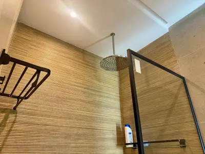 a bathroom with a wooden wall and a light fixture at Luxury Oasis Apartment -Rooftop Pool & Home Cinema in Casablanca