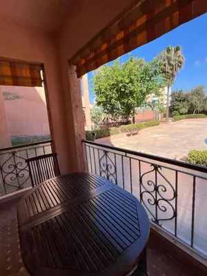 a balcony with a table and a view of a patio at Joli appartement Ricoflores El Mansouria in O Ben Slimane