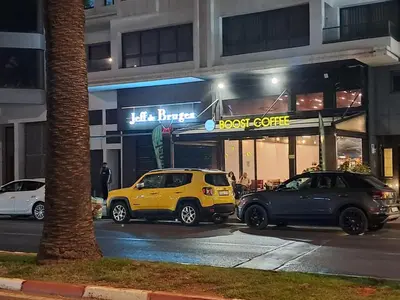two cars parked in front of a food court at night at Riviera Escape - Appart Neuf Climatisé avec Balcon à Maarif Anfa in Casablanca