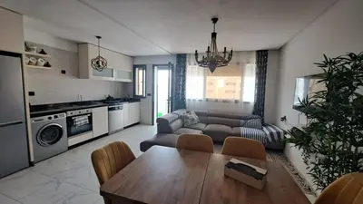 a living room with a table and a couch at Bel appartement près de la plage pour Famille in El Harhoura