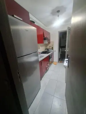 a kitchen with red cabinets and a stainless steel refrigerator at Résidence marbella mansouria in Mansouria