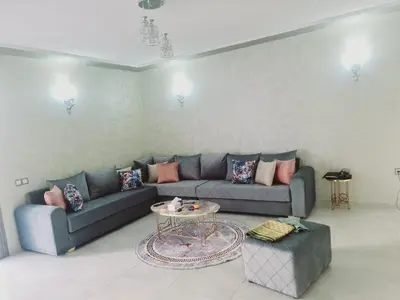 a living room with a couch and a table at Résidence marbella mansouria in Mansouria
