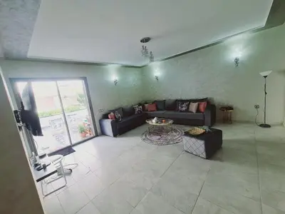 a living room with a couch and a table at Résidence marbella mansouria in Mansouria